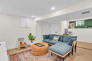 Living room with light wood-type flooring, recessed lighting, and an office area