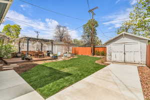 Fenced backyard featuring a deck, a shed, outdoor dining space, and a patio area