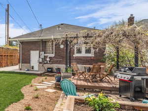 Rear view of house with brick siding, a patio, a fenced backyard, and a deck