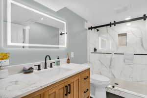 Full brand-new bathroom with vanity, a marble finish shower, and recessed lighting