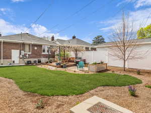 Fenced backyard with a wooden deck, a patio area, and a garden