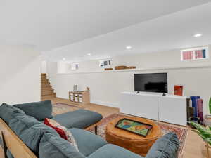 Living area with light wood-style flooring and recessed lighting