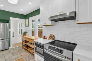 Kitchen featuring stainless steel appliances, white cabinets, and recessed lighting
