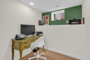 Office space with wood finished floors and recessed lighting