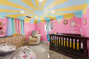 Carpeted bedroom featuring a crib and recessed lighting