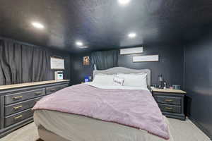 Bedroom featuring light carpet, recessed lighting, and a textured ceiling