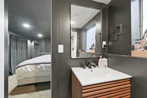 Ensuite bathroom with vanity, a textured ceiling, and recessed lighting