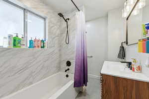 Bathroom with vanity and shower / bath combination with curtain