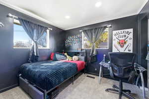 Bedroom with light colored carpet and crown molding