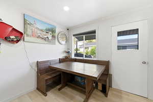 Dining area with ornamental molding, light wood-type flooring, and recessed lighting