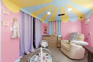 Living area with light carpet and recessed lighting