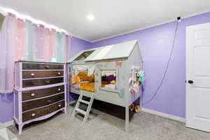 Bedroom with light carpet and crown molding