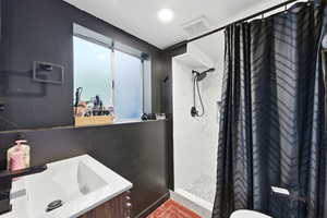 Full bath featuring vanity, a shower stall, and recessed lighting