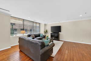 Living area featuring hardwood flooring, ornamental molding, and recessed lighting