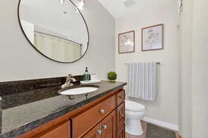 Full size bathroom featuring granite counter tops and tiling.
