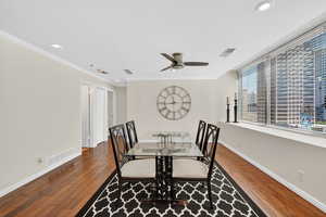 Formal dining room area with hardwood flooring, ceiling fan, recessed lighting, and ornamental molding. East facing natural lighting and large windows.