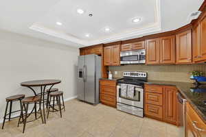 Kitchen with stainless steel appliances, wood finish cabinetry, granite counters, and recessed lighting.