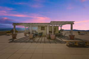 Rooftop pergola and entertainment area with seating and bbq area.