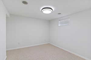 Spare room with carpet flooring and a textured ceiling
