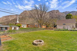 Fenced backyard with a fire pit, a mountain view, and a garden