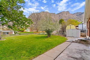 Fenced yard featuring a shed and a mountain view
