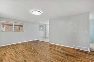 Spare room with light wood finished floors and a textured ceiling