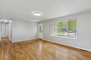 Unfurnished room with light wood-style flooring and a textured ceiling