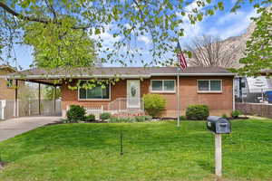 Single story home featuring an attached carport, brick siding, and concrete driveway