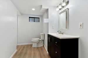 Half bathroom featuring vanity and light wood-type flooring