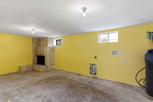 Basement featuring plenty of natural light, a fireplace, a textured ceiling, and a water softener system