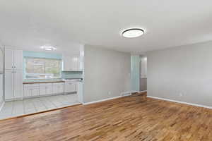 Unfurnished living room with light wood-style flooring and a textured ceiling