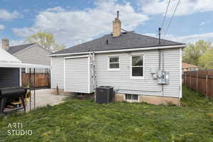 Rear view of property featuring a chimney and roof with shingles