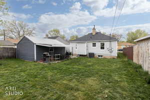 Rear view of house featuring a fenced backyard, a patio, and a chimney