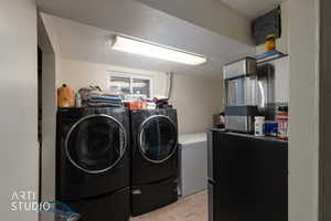 Laundry area with a textured ceiling, washer and dryer, and light tile patterned floors