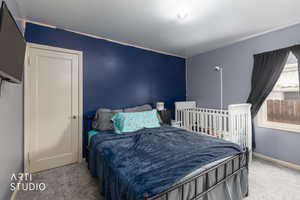 Bedroom featuring light colored carpet and baseboards