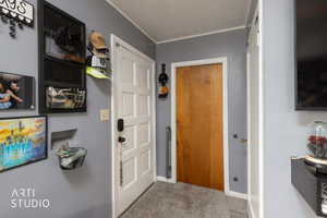 Entryway featuring carpet flooring and crown molding