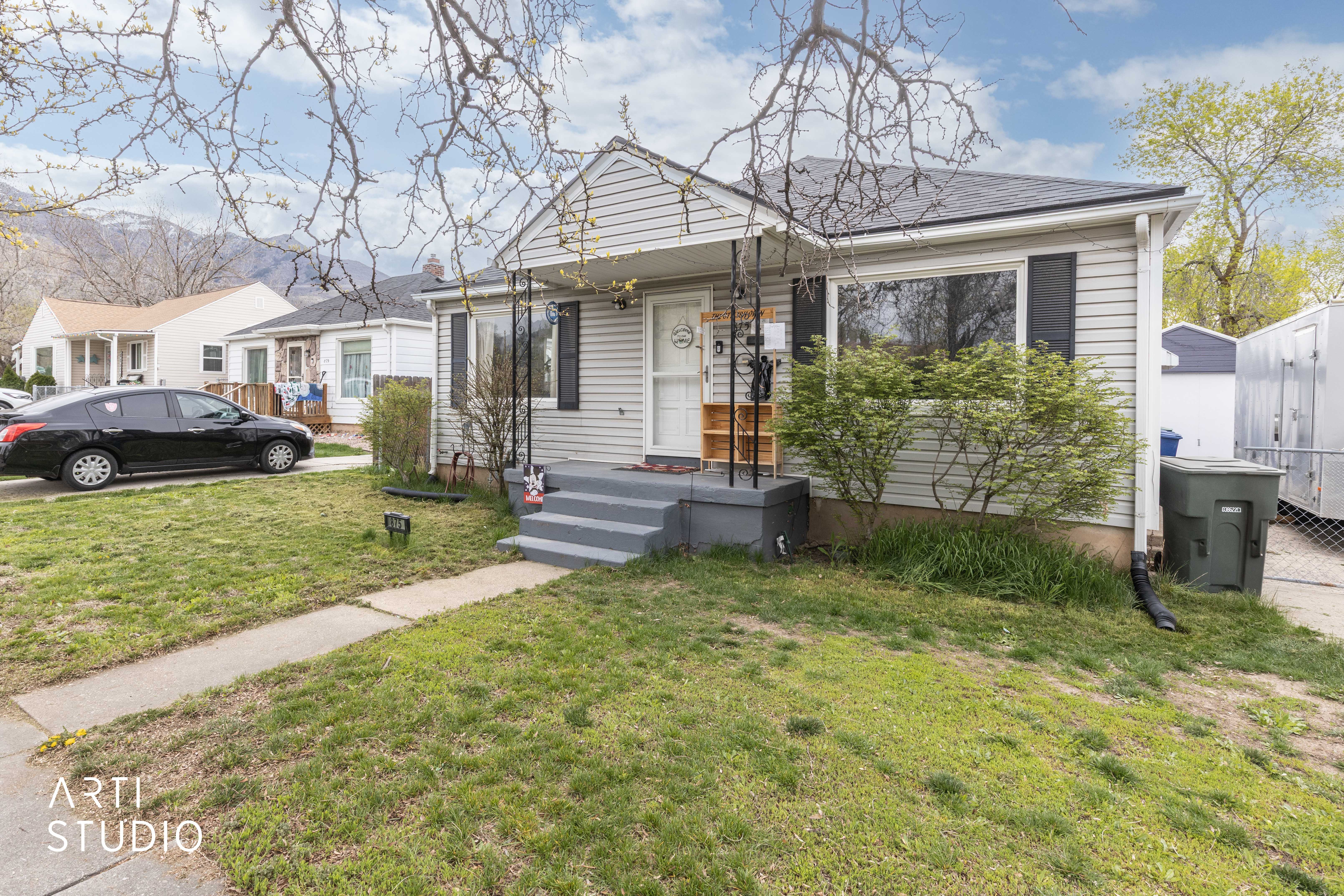 View of front of home featuring a front yard and a storage unit