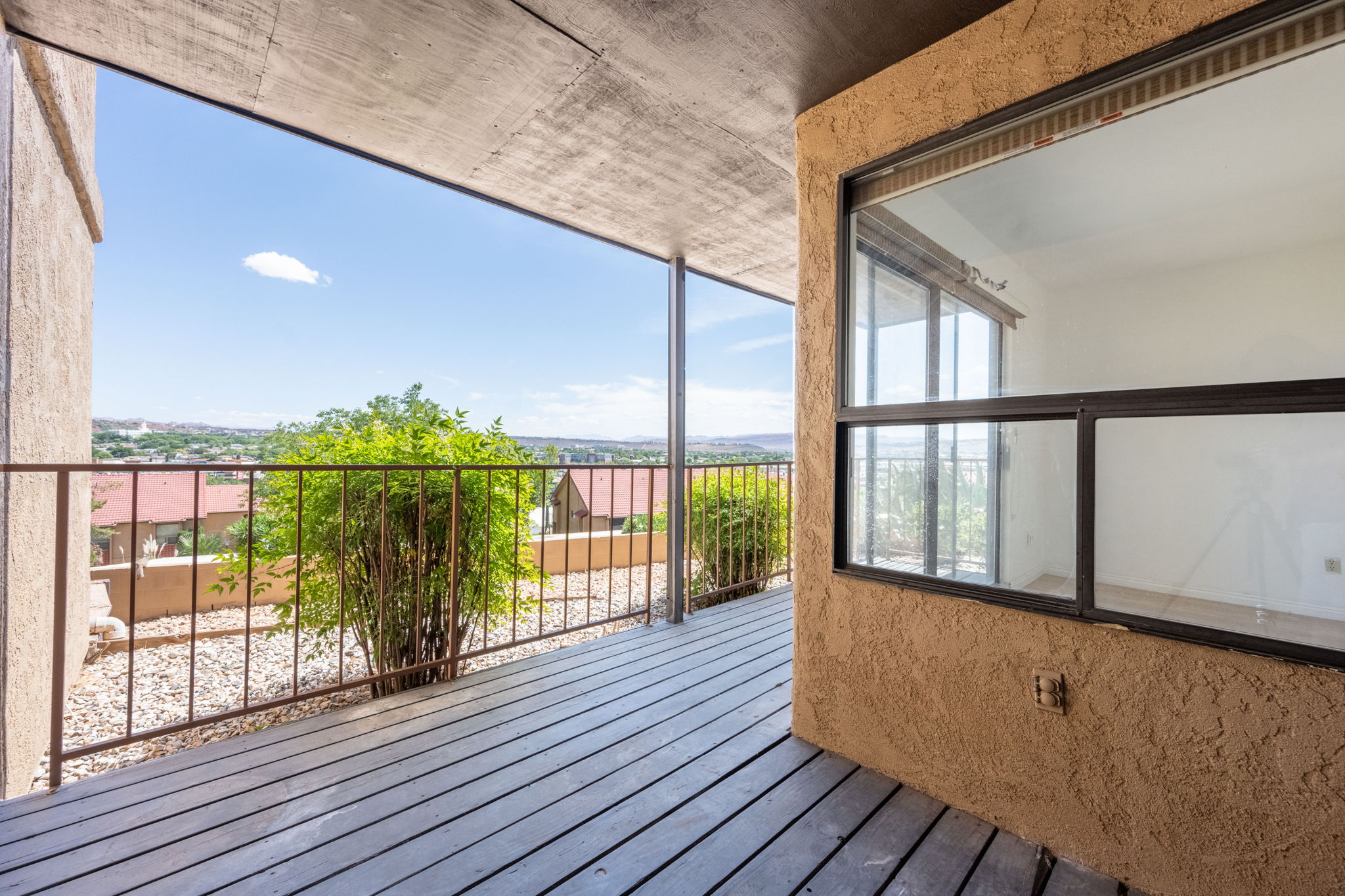 Private balcony with wood-finish decking and metal railings