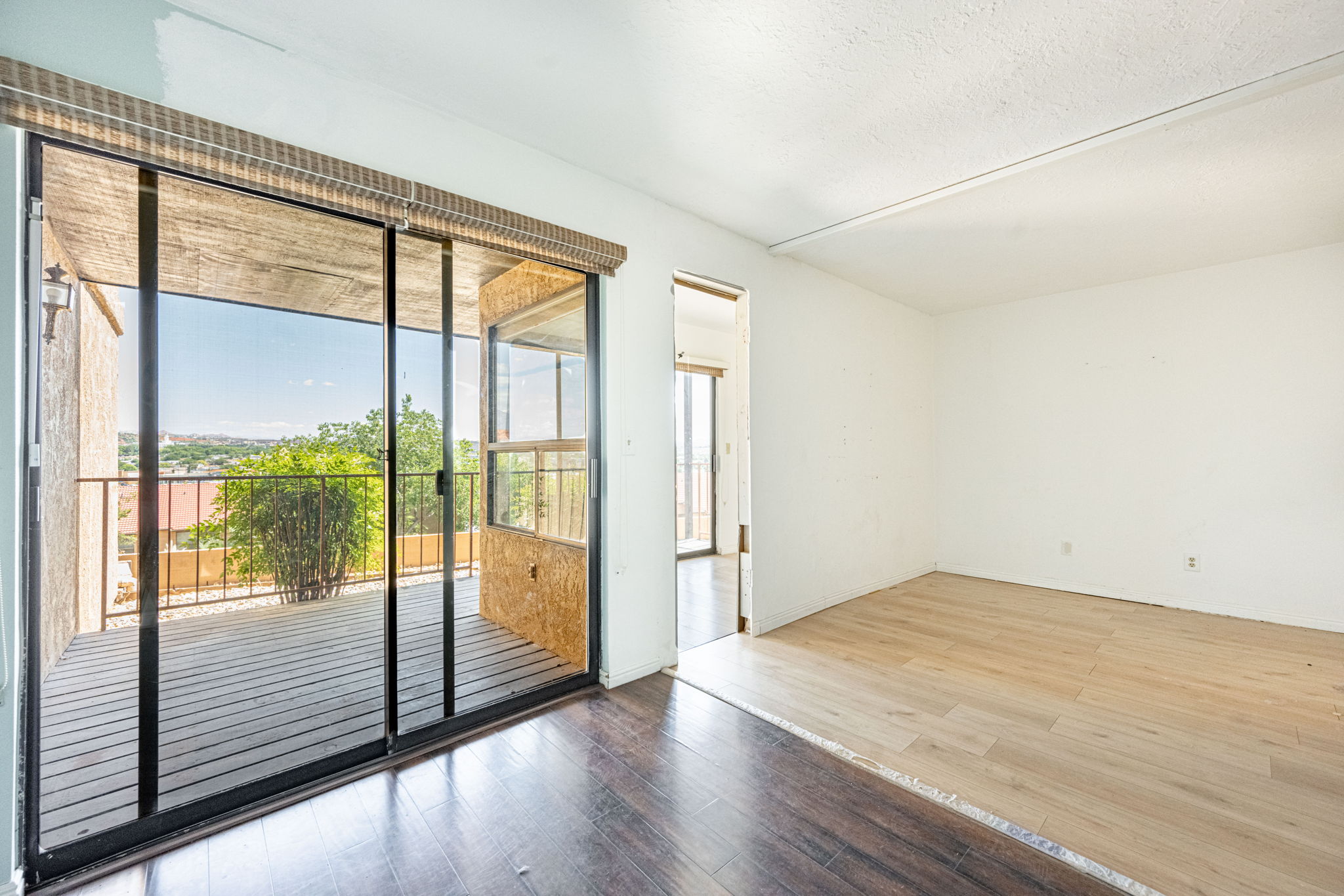Spacious room with sliding glass doors opening to an outdoor deck featuring an iron railing