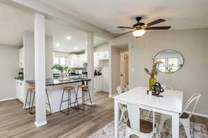 Dining area with dark wood-type flooring, vaulted ceiling, recessed lighting, and ceiling fan