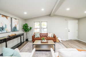 Living area with light wood-style flooring, recessed lighting, and beamed ceiling