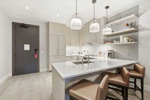 Kitchen with light wood finish cabinets, a kitchen bar, a peninsula, open shelves, and pendant lighting