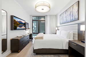 Bedroom featuring light wood finished floors and expansive windows