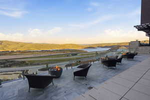 Patio terrace at dusk featuring a patio area, a mountain view, and an outdoor living space with a fire pit
