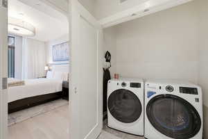 Laundry area featuring light wood finished floors and washing machine and dryer