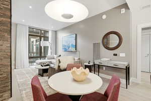 Dining area with expansive windows, light wood-style floors, and recessed lighting