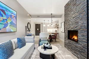 Living room with a stone fireplace and light wood-style floors