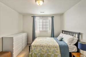 Bedroom with carpet floors and a textured ceiling