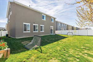Back of property with a fenced backyard and stucco siding
