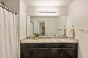 Full bath featuring vanity and curtained shower